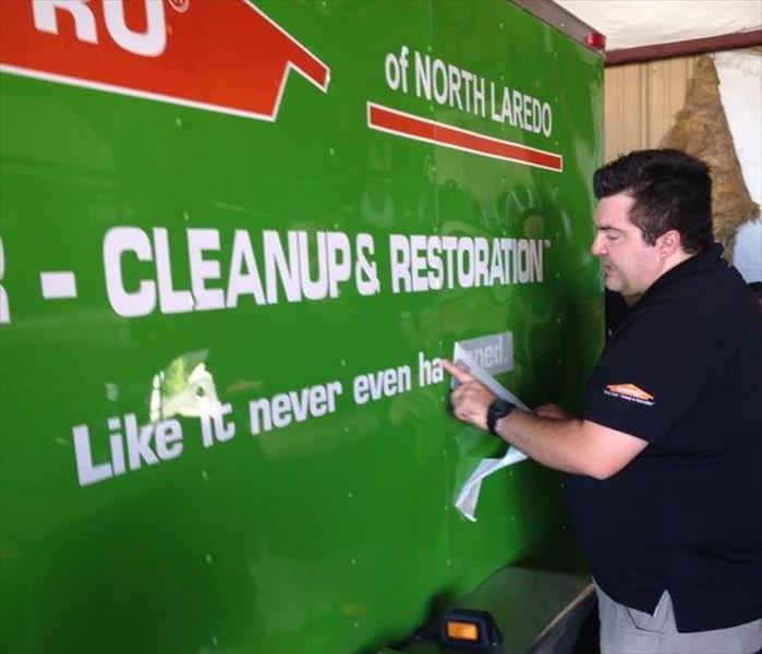 SERVPRO owner adjusts new decal to one of the company's new vehicles